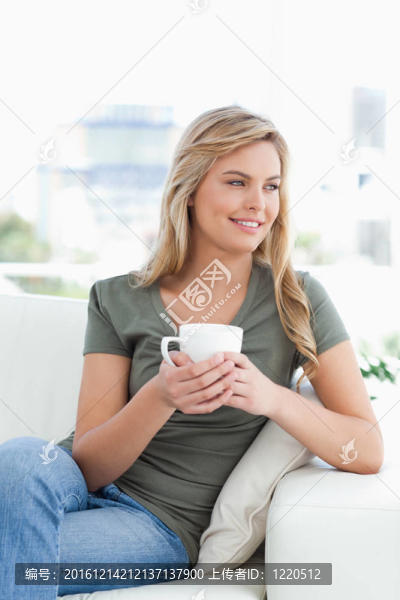 手里拿著杯子的女人；微笑著望向一邊