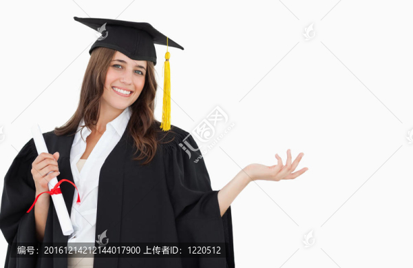 一個面帶微笑的女人，畢業(yè)后手里拿著學位，手里拿著一只手看著相機。