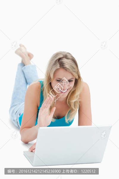 一個拿著筆記本電腦的女人把手伸起來，躺在地板上