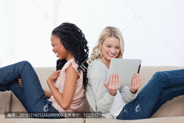 兩個坐在后面笑的女人有一臺平板電腦