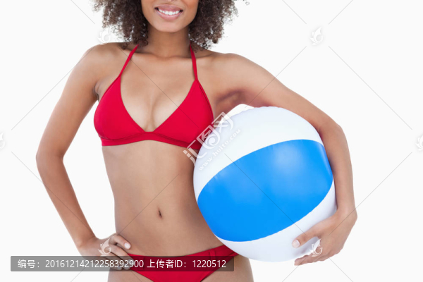 微笑的黑發(fā)女人抱著一個沙灘球