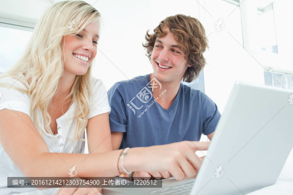 一對(duì)夫婦使用筆記本電腦，一個(gè)男人看著女人