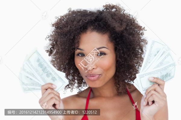 漂亮的黑發(fā)女人蹙起她的嘴唇，握著扇子的鈔票