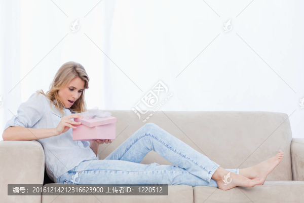 一個(gè)驚訝的女人打開一個(gè)粉紅色的盒子里面有一個(gè)禮物