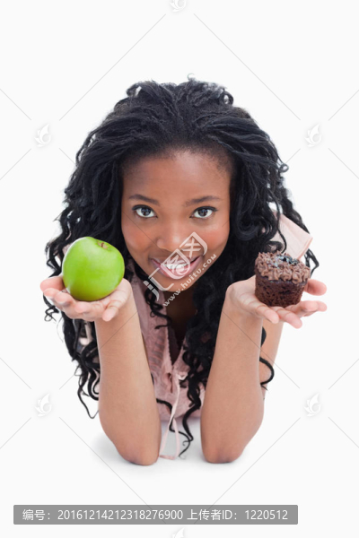 一位面帶微笑的年輕女子手持一個蘋果和一個小圓面包，放在懷里的白色背景上