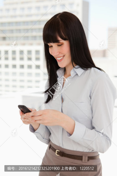 微笑的女人在工作時(shí)發(fā)短信