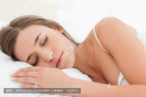 女人睡在床上，手放在她面前