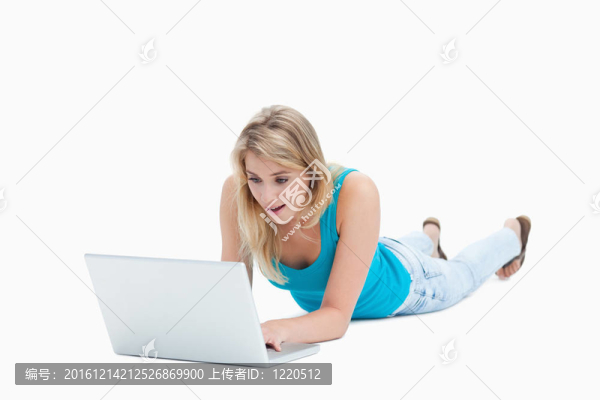 一個驚訝的女人看著筆記本電腦躺在地板上