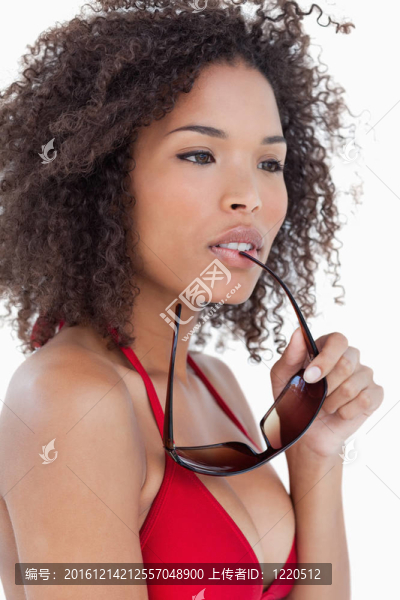 年輕女子一邊拿著墨鏡一邊看了看