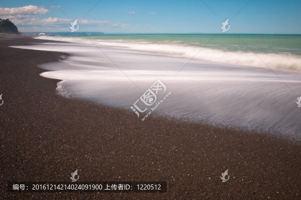 在晴朗的卵石海灘沖浪