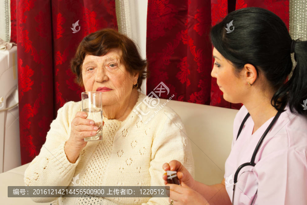 給老人喂藥丸和水