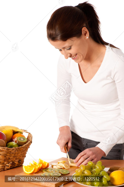 年輕漂亮的女人切水果和制作水果沙拉