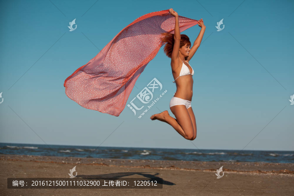 美麗的女子跳的喜悅沙漠海灘