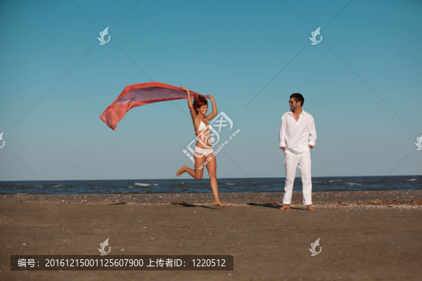 快樂的；年輕的夫婦沿著海岸