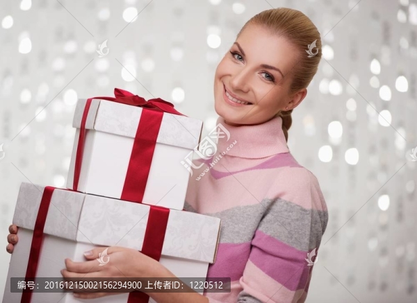 微笑女子在羊絨衫與禮品盒。