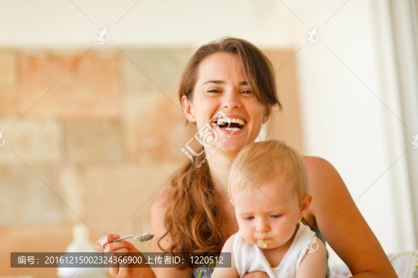 笑的年輕母親喂養(yǎng)嬰兒肖像