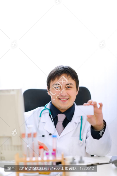 面帶微笑的醫(yī)生坐在辦公桌旁，手里拿著空白名片