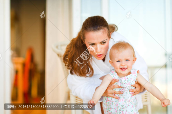 在浴衣告訴她可愛的嬰兒的年輕母親