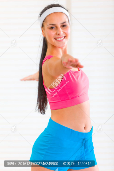 微笑的年輕女孩在客廳做體操