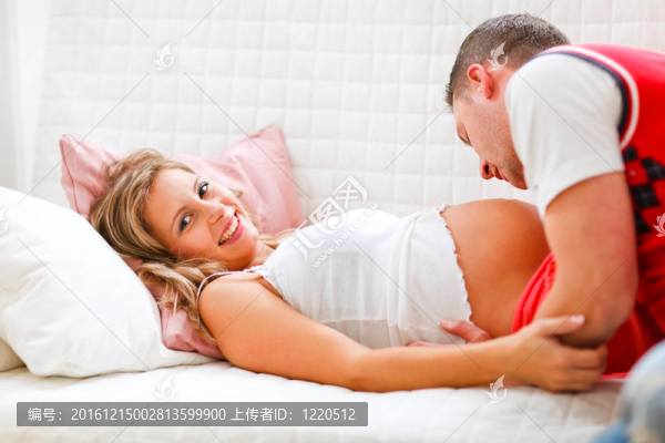 年輕人接吻他懷孕的妻子的肚子