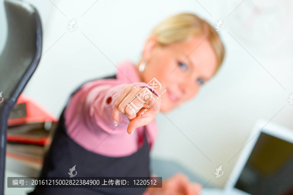 現(xiàn)代商務(wù)女性坐在辦公桌前指著你