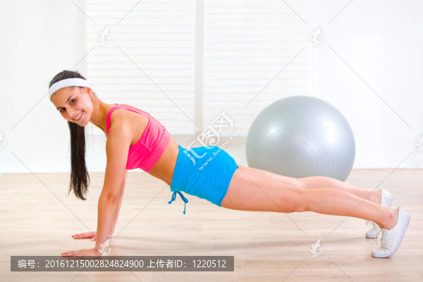 快樂健身女孩做俯臥撐練習(xí)在家里