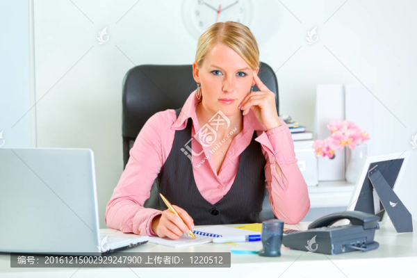嚴(yán)肅的現(xiàn)代商業(yè)女性坐在辦公桌旁的畫像