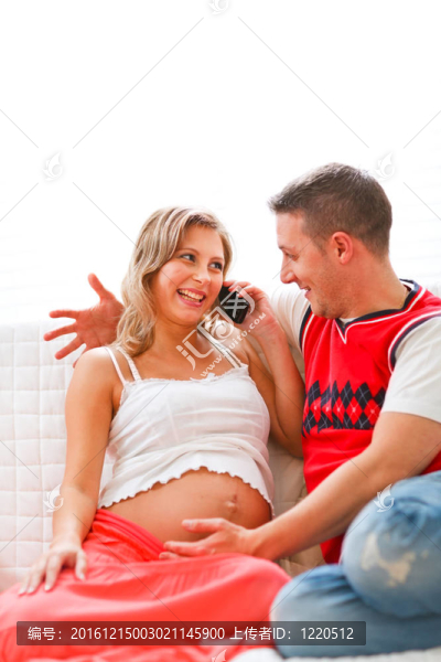 年輕孕婦坐在沙發(fā)上與丈夫通話