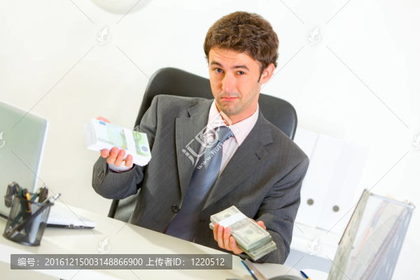 權威現(xiàn)代商人坐在辦公桌前提供貨幣包