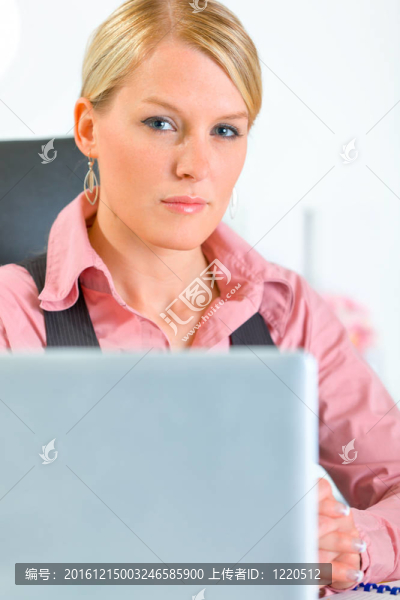 自信的現(xiàn)代商務(wù)女性坐在辦公桌前。特寫