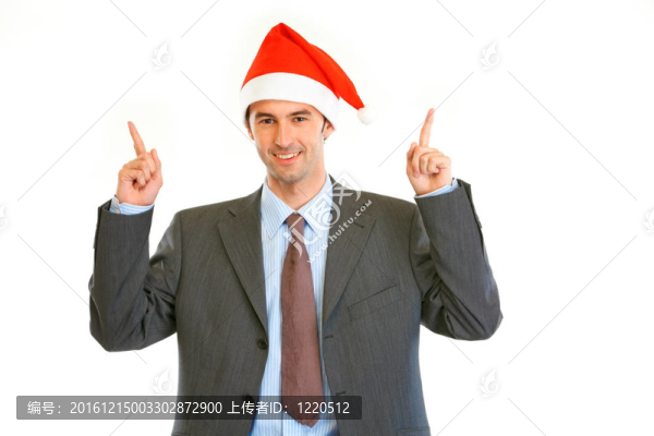 微笑的年輕商人在Santa的帽子指著手指在復(fù)制空間孤立的白色