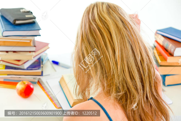 研究少女坐在桌子上與成堆的書(shū)籍