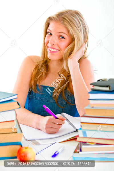 微笑的少女坐在桌子旁，手里拿著許多書