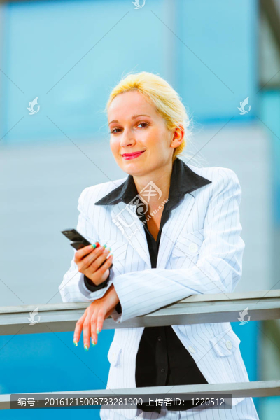 辦公樓靠手機(jī)的現(xiàn)代商務(wù)女性