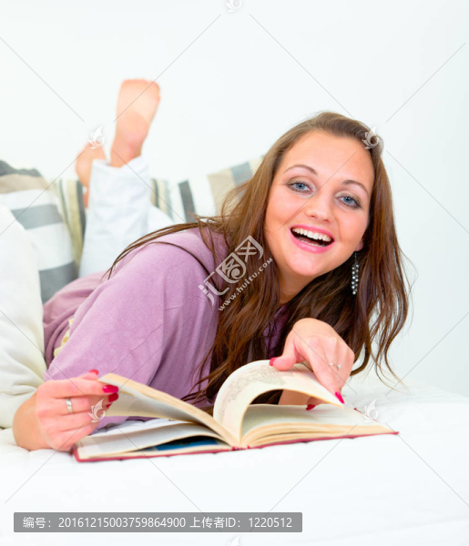 笑漂亮的女人躺在沙發(fā)上看書