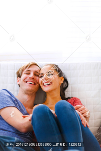 年輕夫婦坐在沙發(fā)上笑