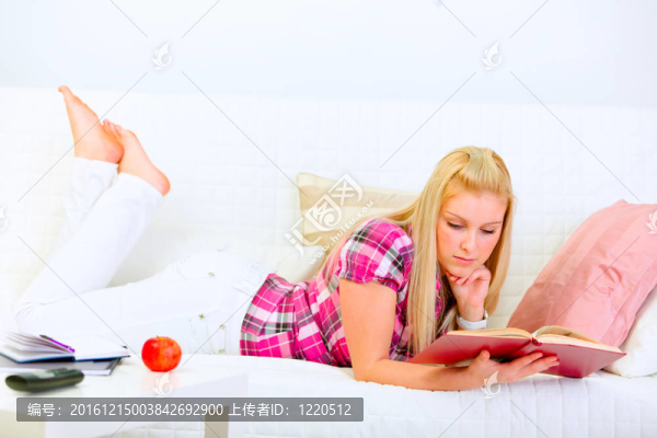 現(xiàn)代家庭主婦躺在沙發(fā)上看書