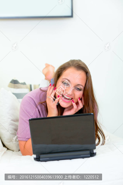 漂亮漂亮的女人躺在家里的沙發(fā)上，用信用卡從網(wǎng)上購(gòu)物
