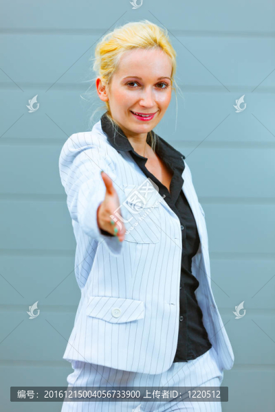 站在辦公樓里微笑著現(xiàn)代商業(yè)女性伸出手來(lái)握手