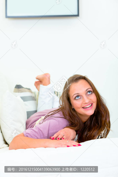 微笑的漂亮女人躺在家里的沙發(fā)上