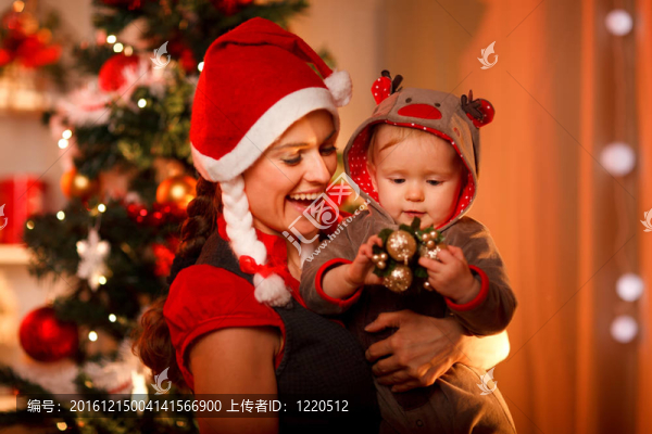 微笑的媽媽在圣誕樹(shù)旁玩?？蓯?ài)的寶貝