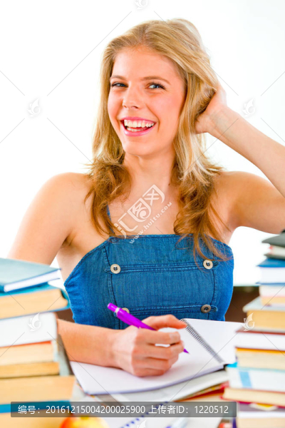 微笑的少女坐在桌子旁，手里拿著許多書
