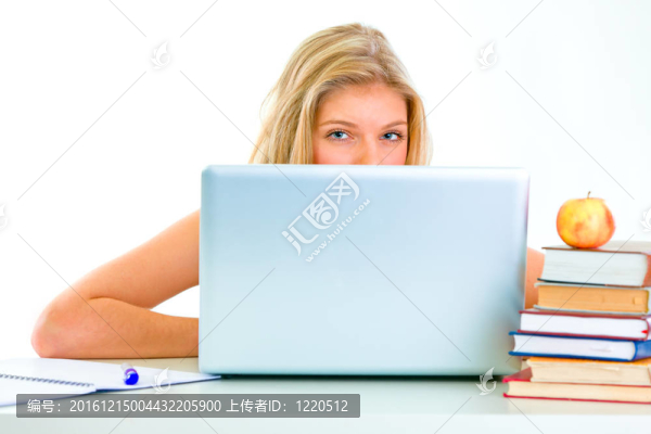 坐在桌上的少女看著筆記本電腦