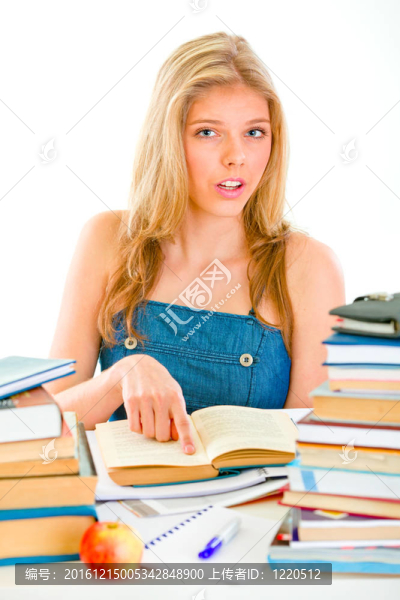 好奇的女孩坐在桌子上指著書