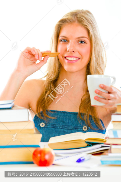 面帶微笑的少女坐在桌旁看書，喝茶