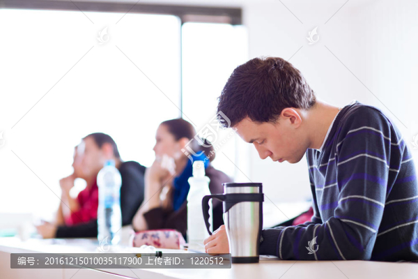 年輕；坐在教室里的英俊男大學(xué)生