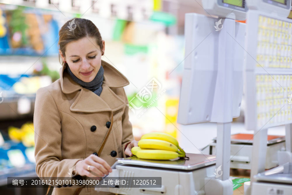 美麗的年輕女人買水果和蔬菜