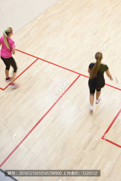 兩名女壁球運動員在壁球場快速動作