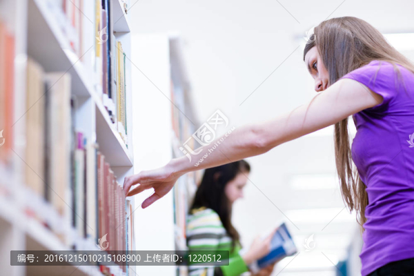 在圖書館-漂亮的女學生與筆記本電腦和書籍