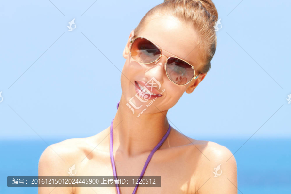 漂亮的女人在海灘與太陽鏡